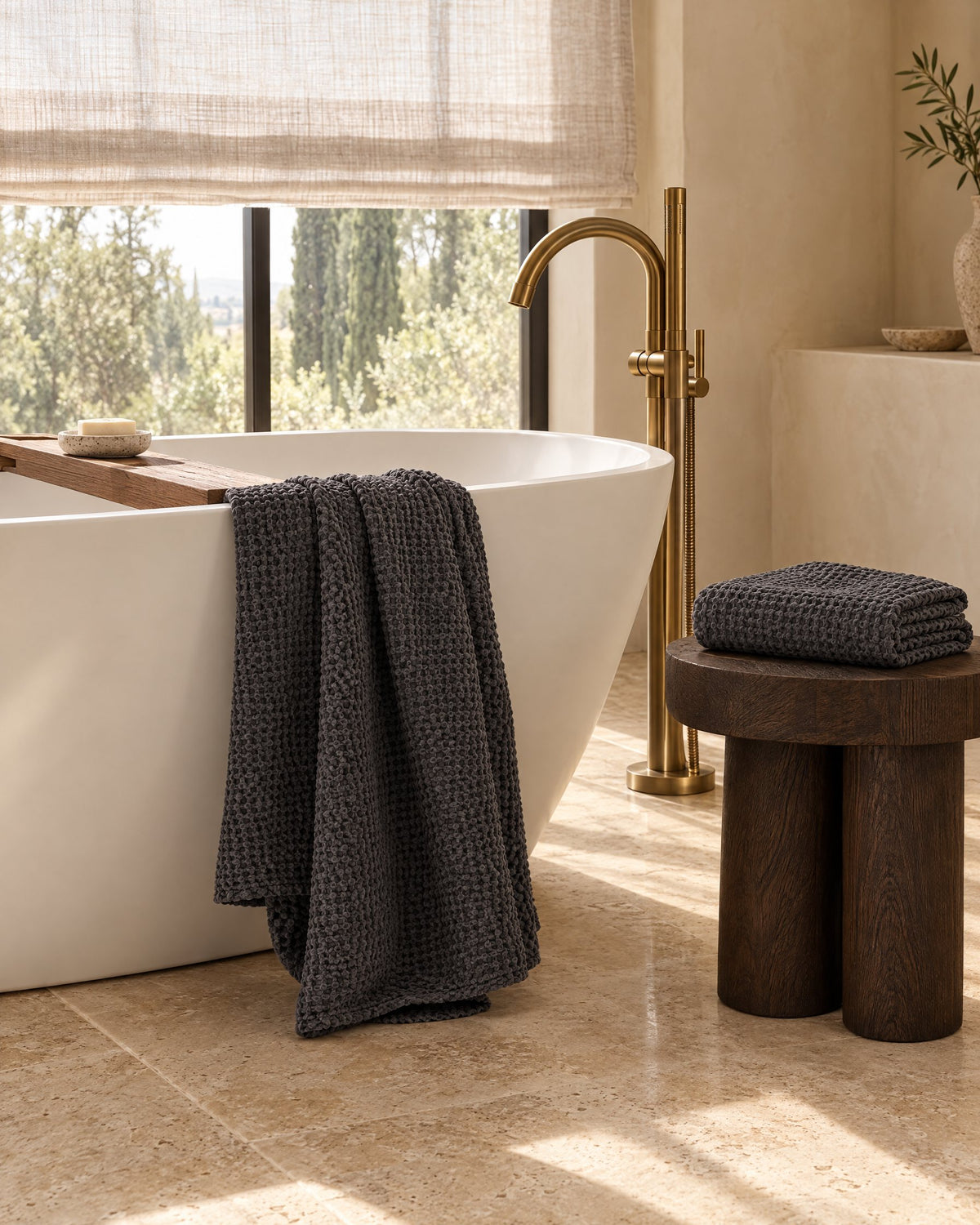 Charcoal waffle towels by a freestanding bathtub